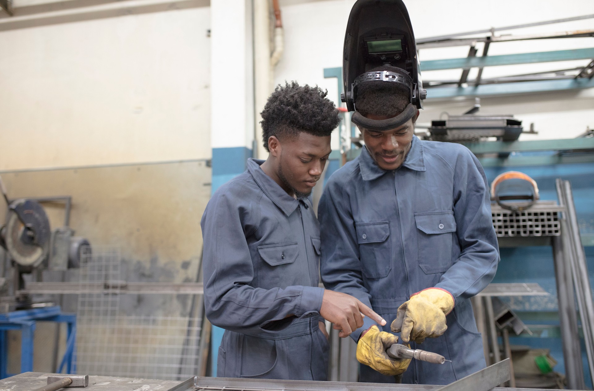 Two afro-american workers working on grid at factory