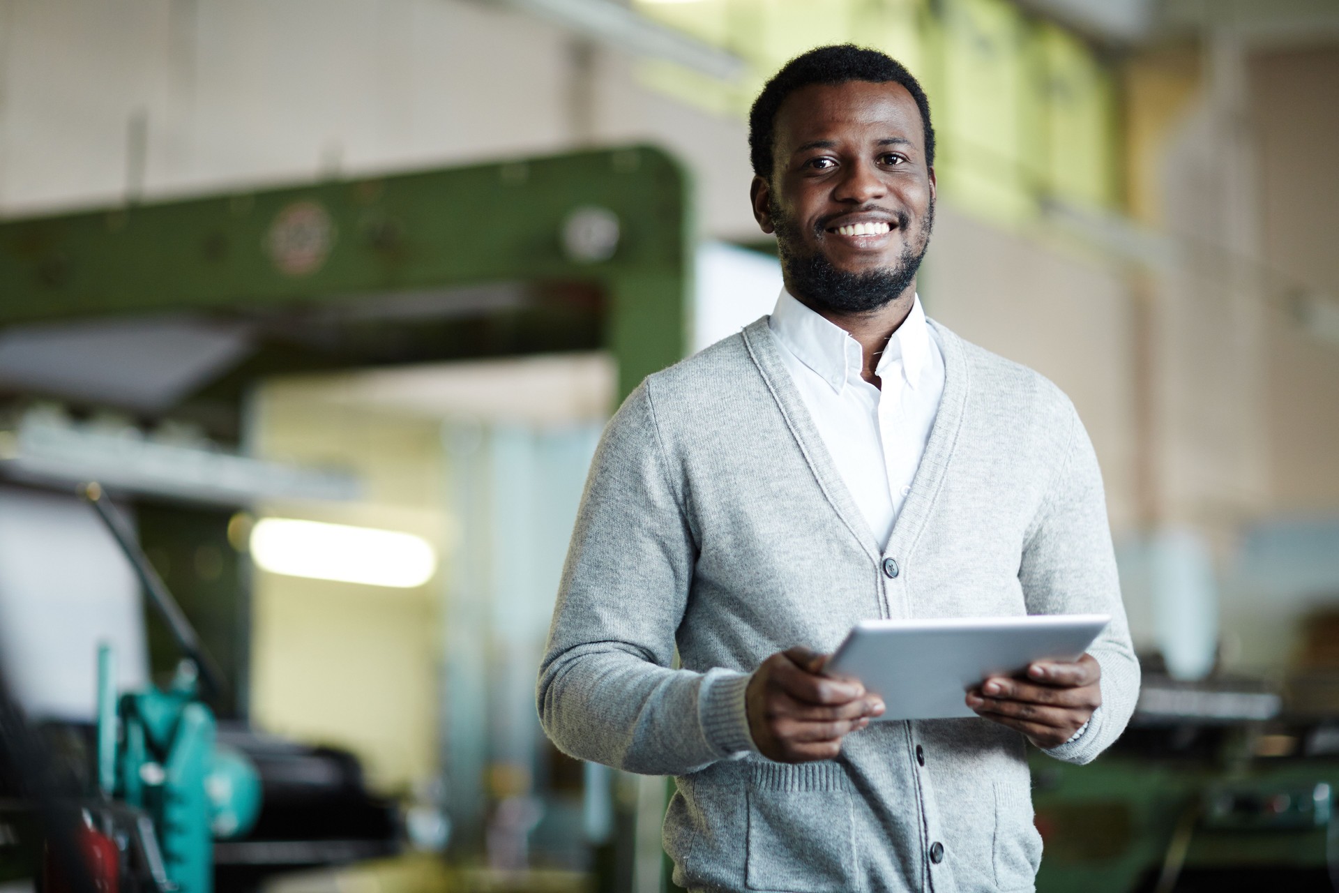 Cheerful confident African printing worker with tablet